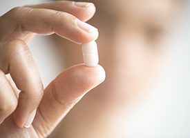 Hand holding a tablet pill