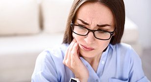 Woman in pain holding cheek